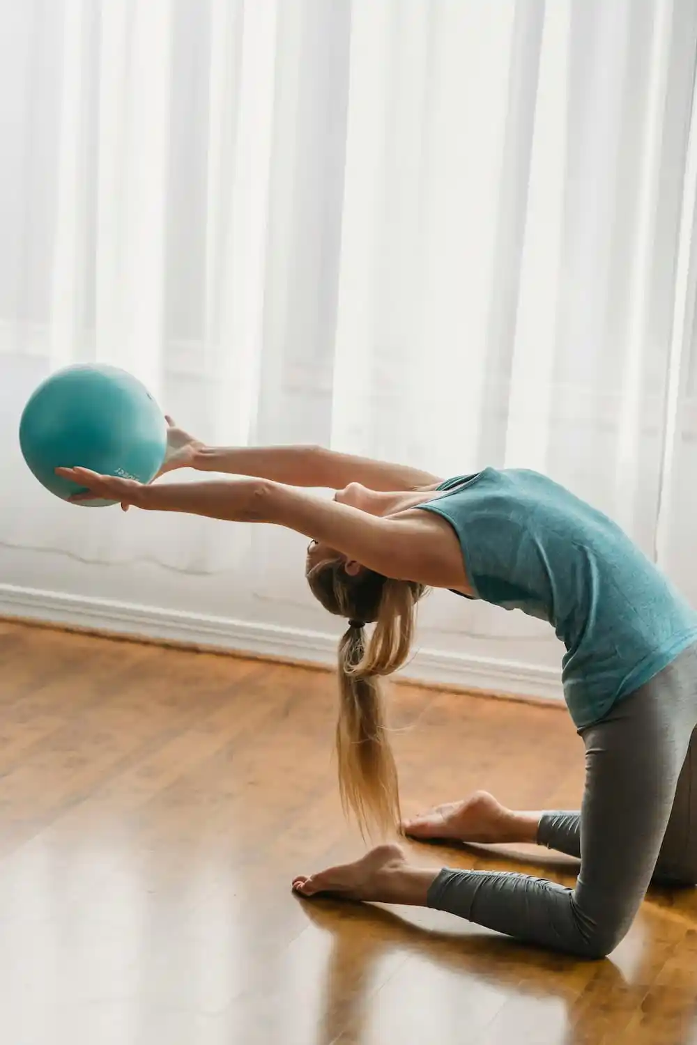 A member in a yoga pose, with a ball