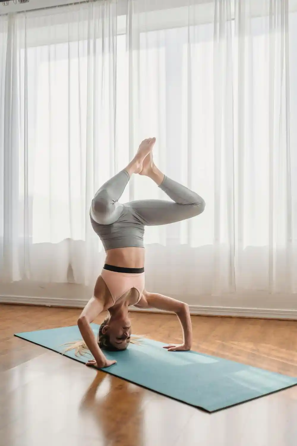 A woman performs an upside-down balance pose